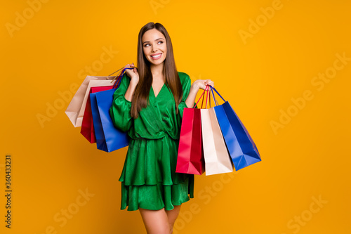 Portrait of her she nice-looking attractive pretty luxury cheerful cheery glad straight-haired girl carrying new clothing isolated over bright vivid shine vibrant yellow color background