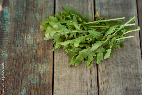 The rucola lies on old wooden boards. With copy space. Top view