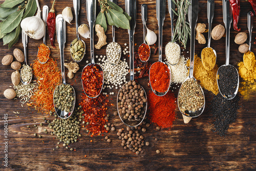 Fototapeta Naklejka Na Ścianę i Meble -  Spices in spoons on dark wooden background top view