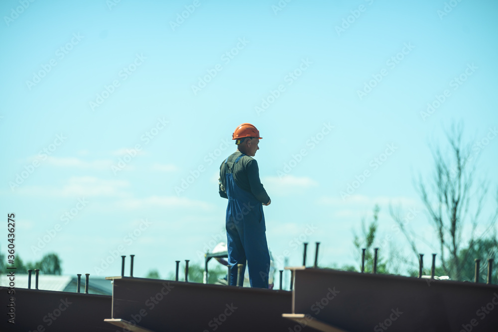 Russia, Saint Petersburg, June 23, 2020: a road worker in a hard hat and overalls. Construction of roads and bridges in the city.