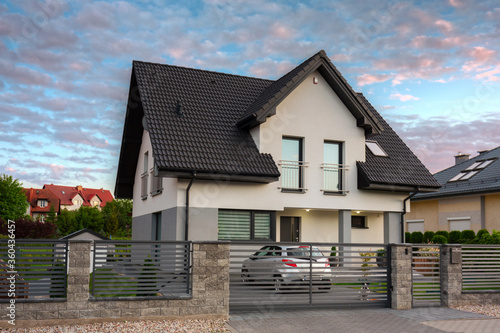 A modern single family house with a garden at sunset