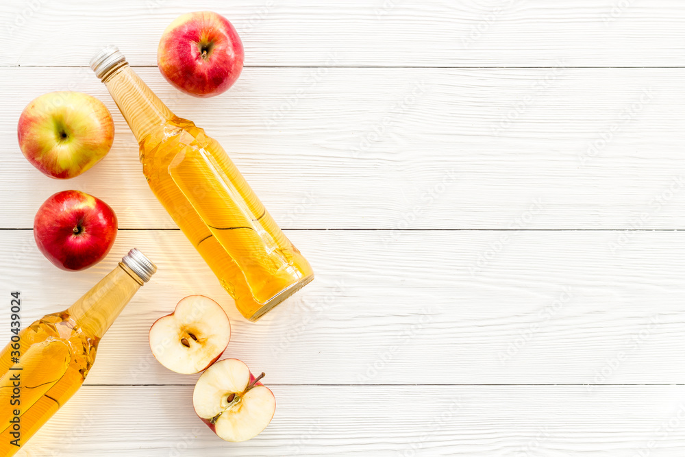 Apple cider vinegar bottle on white desk top-down space for text Apple cider vinegar bottle on white desk top-down space for text