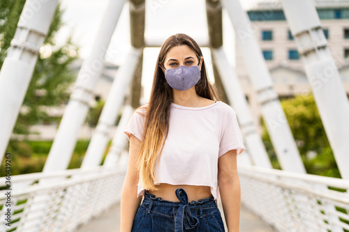 Portrait of a young woman wearing a trendy face mask for protection against covid-19 Coronavirus © gabriele