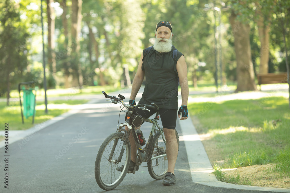 Senior man on cycle ride in countryside. Bearded mature man cycling. Senior man on cycle ride in countryside. Bearded mature man cycling.