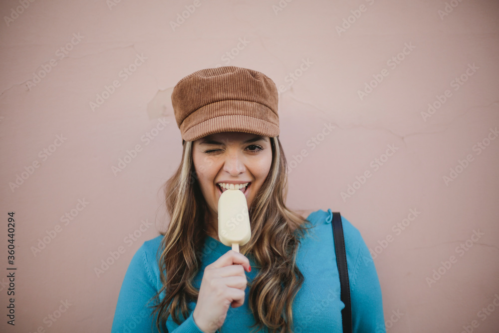 Blonde girl is eating ice-cream on a colarated background Blonde girl is eating ice-cream on a colarated background