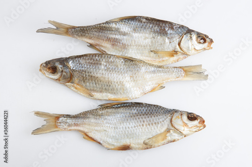 isolated close up top view shot of three Russian dried salted vobla (Caspian Roach) fish on a white background