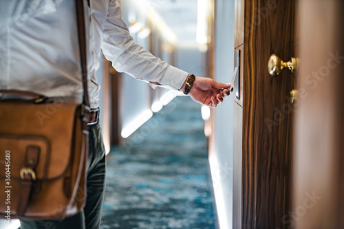 Φωτογραφία Man entering hotel room with key card, close-up.