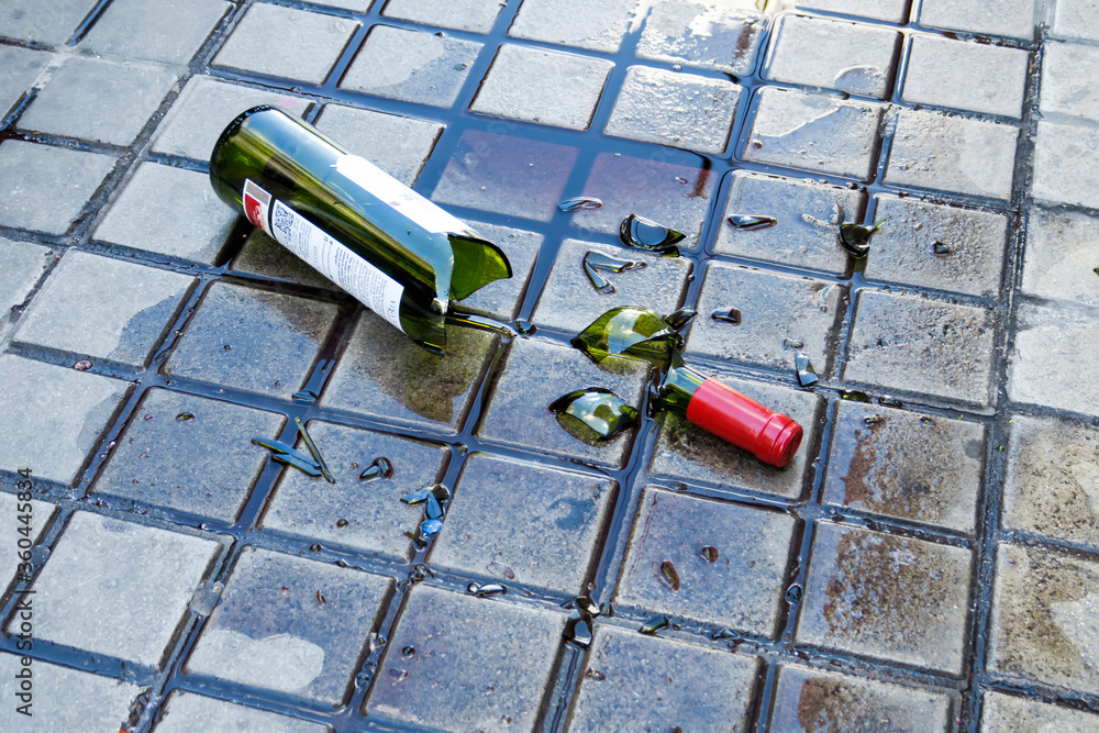broken red wine bottle on the floor