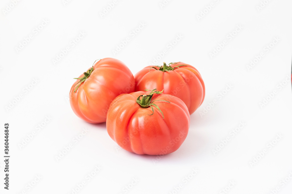 Closeup of pink beef tomatoes on a white background Closeup of pink beef tomatoes on a white background