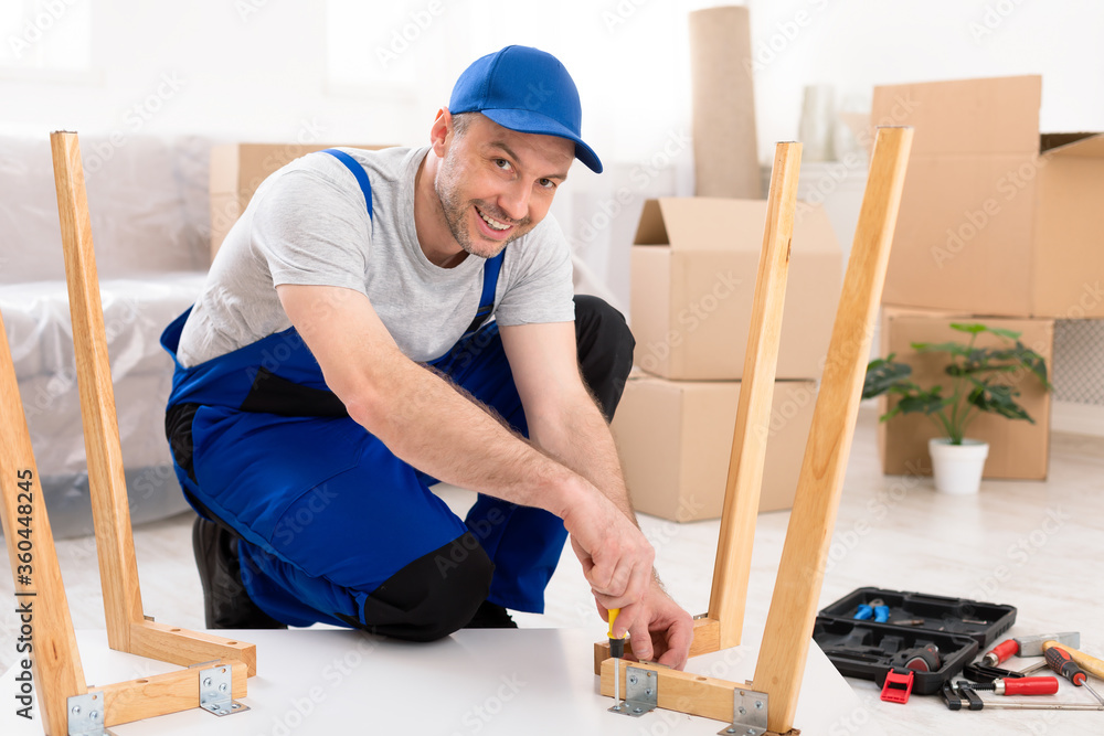 Professional Carpenter Assembling Table Sitting On Floor In Room Professional Carpenter Assembling Table Sitting On Floor In Room