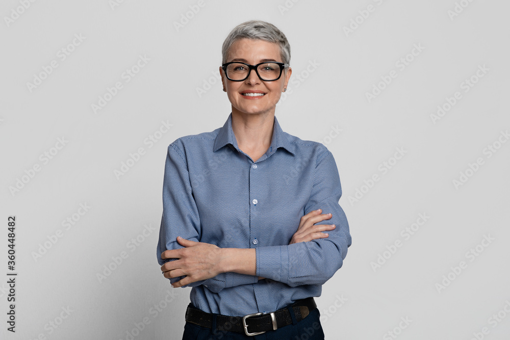 Portrait Of Attractive Mature Businesswoman In Stylish Eyeglasses Posing With Folded Arms - obrazy, fototapety, plakaty 