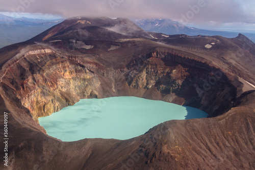 Daytime view of the mouth of a volcano in clear sunny weather. View of a salt lake in the mouth of an active volcano