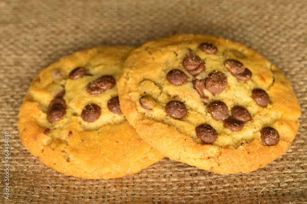 Homemade cookies with chocolate, close-up, on jute fabric.