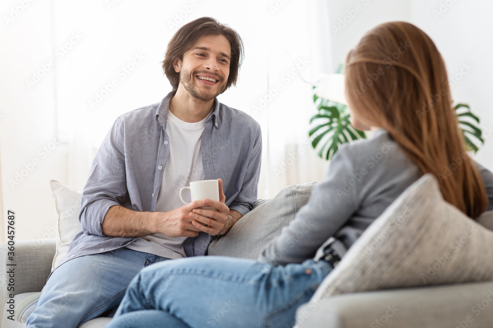 Happy guy drinking coffee and talking to girlfriend at home Happy guy drinking coffee and talking to girlfriend at home