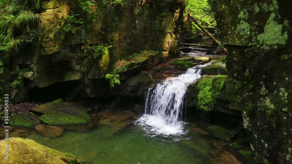 Waterfalls in green forest during a summer, exposure with a long time. The river Satina in the Beskydy Mountains, Czech Republic, Europe. Waterfalls in green forest during a summer, exposure with a long time. The river Satina in the Beskydy Mountains, Czech Republic, Europe.
