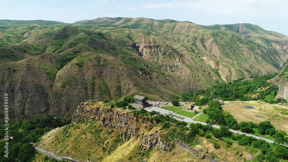Aerial view of a Hellenic temple in the middle of the rocky hill having enormous mountains Aerial view of a Hellenic temple in the middle of the rocky hill having enormous mountains