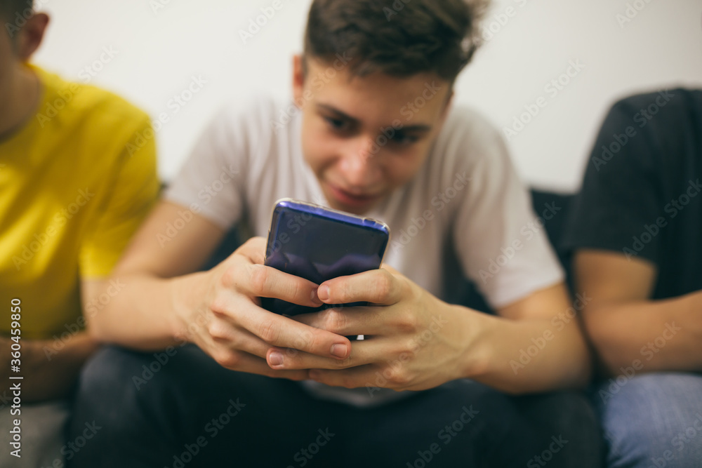 teenager boys having fun at home, using mobile phones