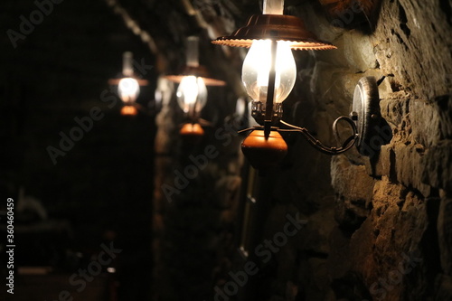 Lampy oświetlające stary kamienny mur