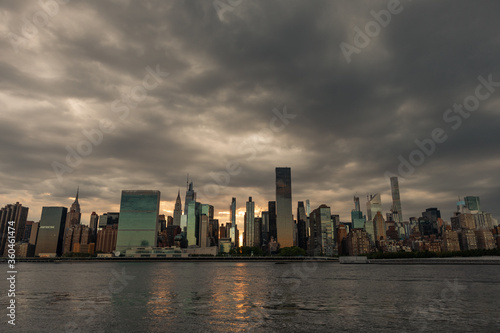Canvas Print Dark and Ominous Sky with the Midtown Manhattan Skyline during a Sunset along th