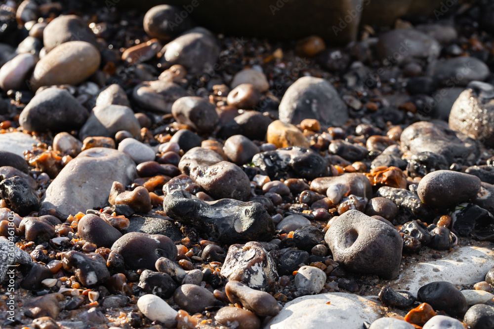 Smooth wet beach stones. North of France, Normandy. Background texture