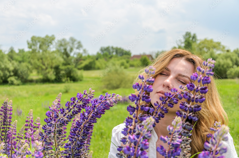Young charming girl with wildflowers lupins Young charming girl with wildflowers lupins