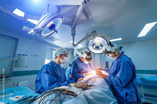 Neurourgeons are operating with medical robotic surgery machine. Modern automated medical device. Surgical room in hospital with robotic technology equipment, machine arm neurosurgeon.