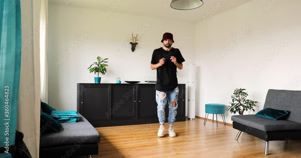 young man dances at home and trains his dance steps young man dances at home and trains his dance steps