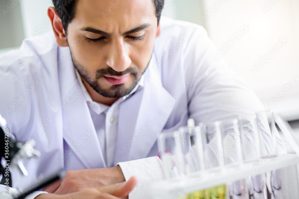 Caucasian scientist man lab technical service observe liquid sample with lab glassware and test tubes in chemical laboratory background, science laboratory research and lab development concept Caucasian scientist man lab technical service observe liquid sample with lab glassware and test tubes in chemical laboratory background, science laboratory research and lab development concept