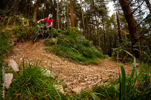 BALLINASTOE, IRELAND. A mountain biker riding a tight corner on a trail through the forest in the purpose built MTB trail centre.
