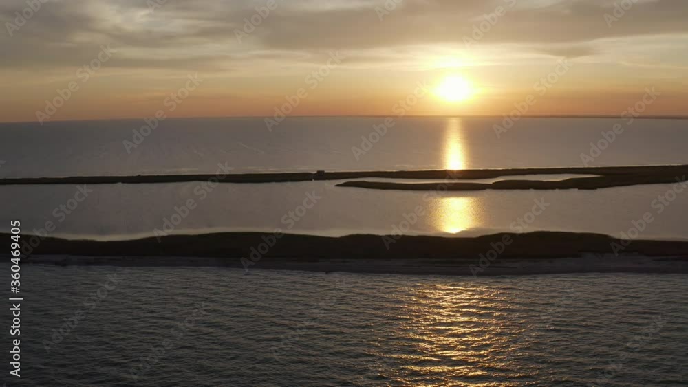 Aerial landscape top view of silhouette of sand spit in Crimea in Black Sea on background of beautiful sunset in summer. Stunning flight over islands and nature reserve and skyline with evening sky. Aerial landscape top view of silhouette of sand spit in Crimea in Black Sea on background of beautiful sunset in summer. Stunning flight over islands and nature reserve and skyline with evening sky.