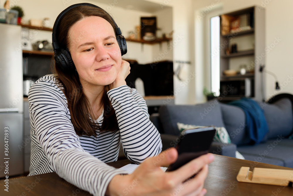 Woman in headphones learning at home Woman in headphones learning at home