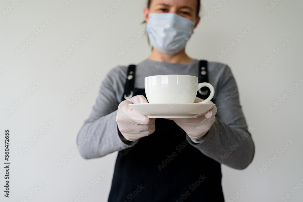 Woman waitress with cup in face mask and gloves Woman waitress with cup in face mask and gloves