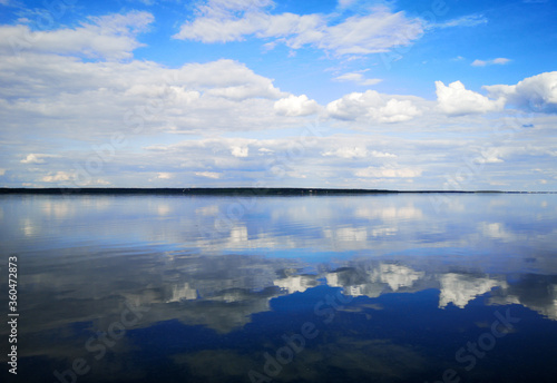 Clouds on a blue sky with reflection in water