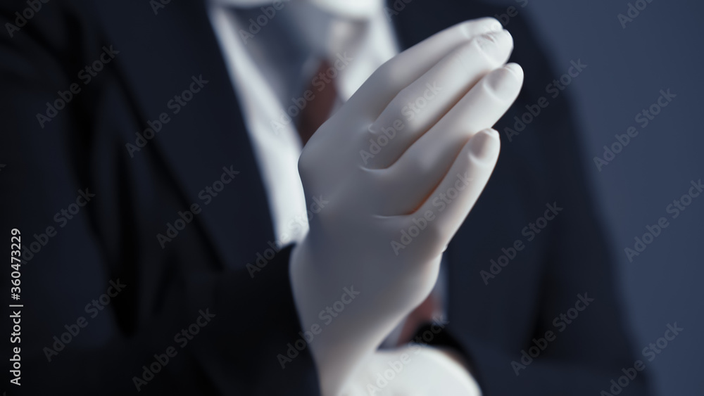 Obraz premium Business person puts on white disposable gloves. Business during and after quarantine. Close up shot.