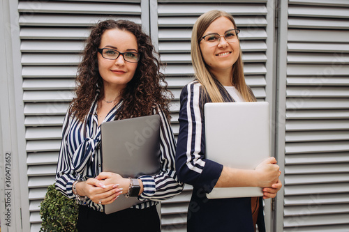 Two beautiful pretty businesswoman girls with laptops 