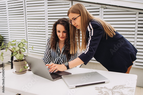 Corporate Communication.Two Businesswoman Working On Laptop In Modern Office. Free Space