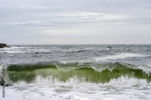 Ocean waves with foam on a shore of sand beach