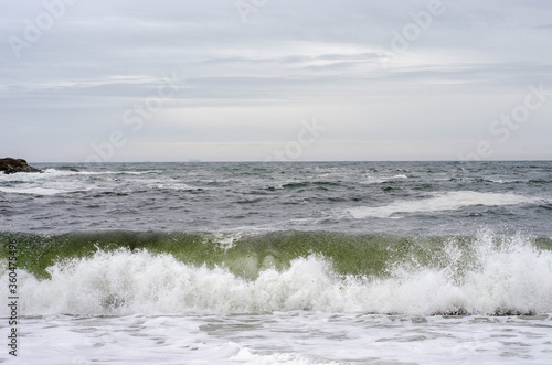 Ocean waves with foam on a shore of sand beach