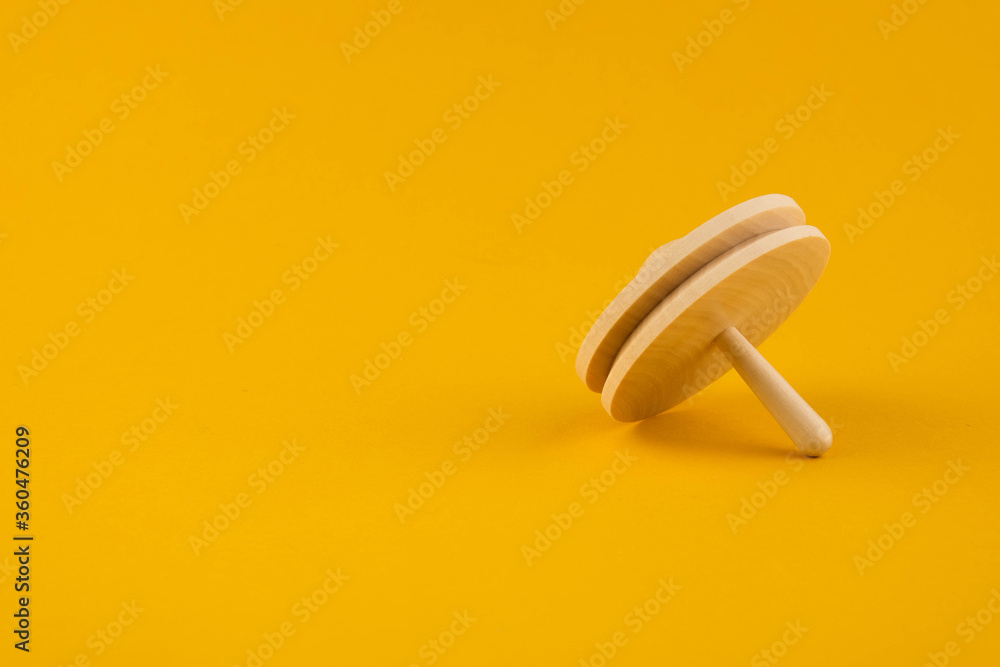 Children's wooden toy spinning top close up with copy space. Concept of educational games Children's wooden toy spinning top close up with copy space. Concept of educational games