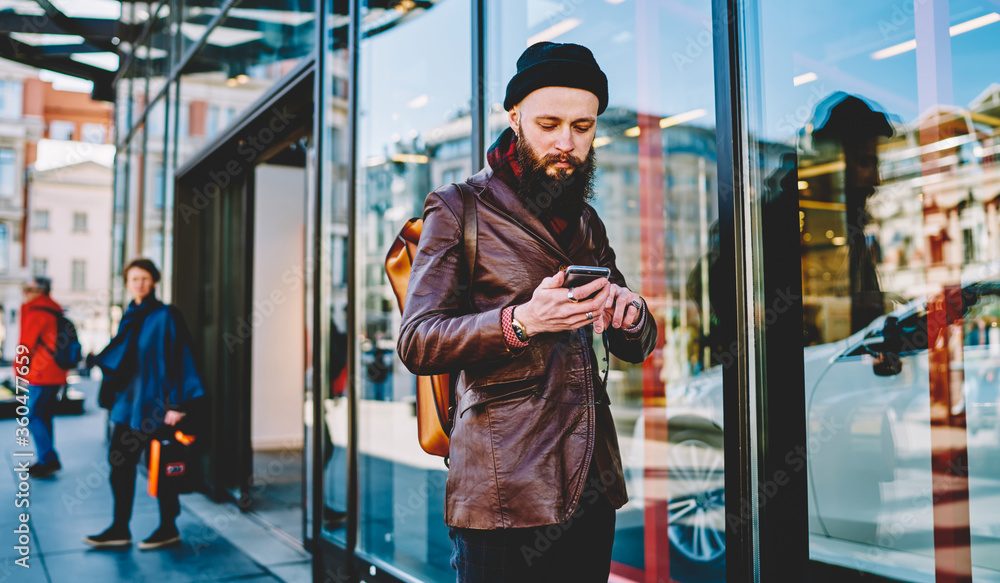 Young bearded man using smartphone in street Young bearded man using smartphone in street