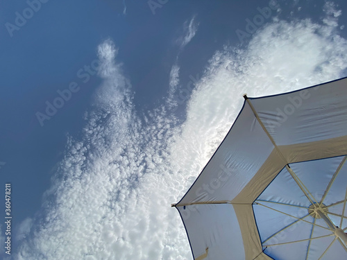 Blue sun umbrella on sky background
