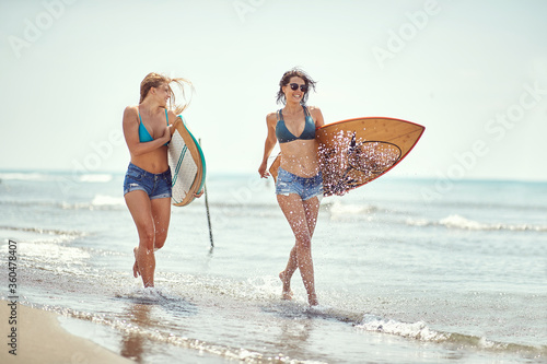 Photography Young woman running to surfing on the beach