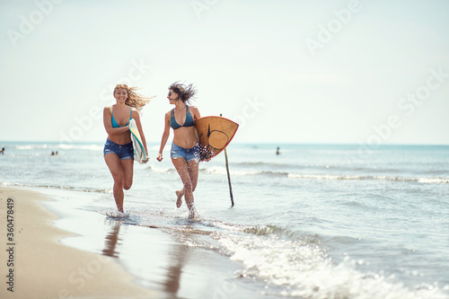 Photography .Young girl running to surfing on the beach.Woman with  surfboard at summer.