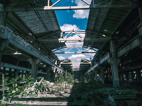 Soviet ruins of the plant. The abandoned building was overgrown with greenery and collapsed.