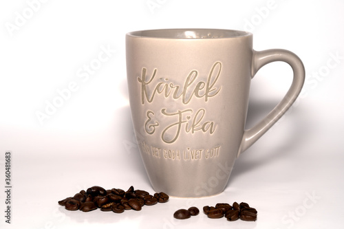 coffee beans and cup on a white background, Coffee cup says "Love and Fika"