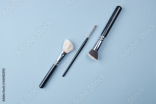 Wallpaper Mural large and small brushes for drawing and make-up on a blue background. copy space for text. top view. Torontodigital.ca