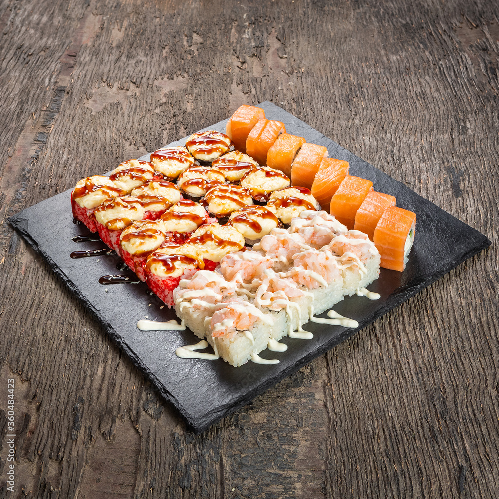 Japanese cuisine. Seafood, vegetables and meat. Sushi and rolls big set isolation on a wooden table background