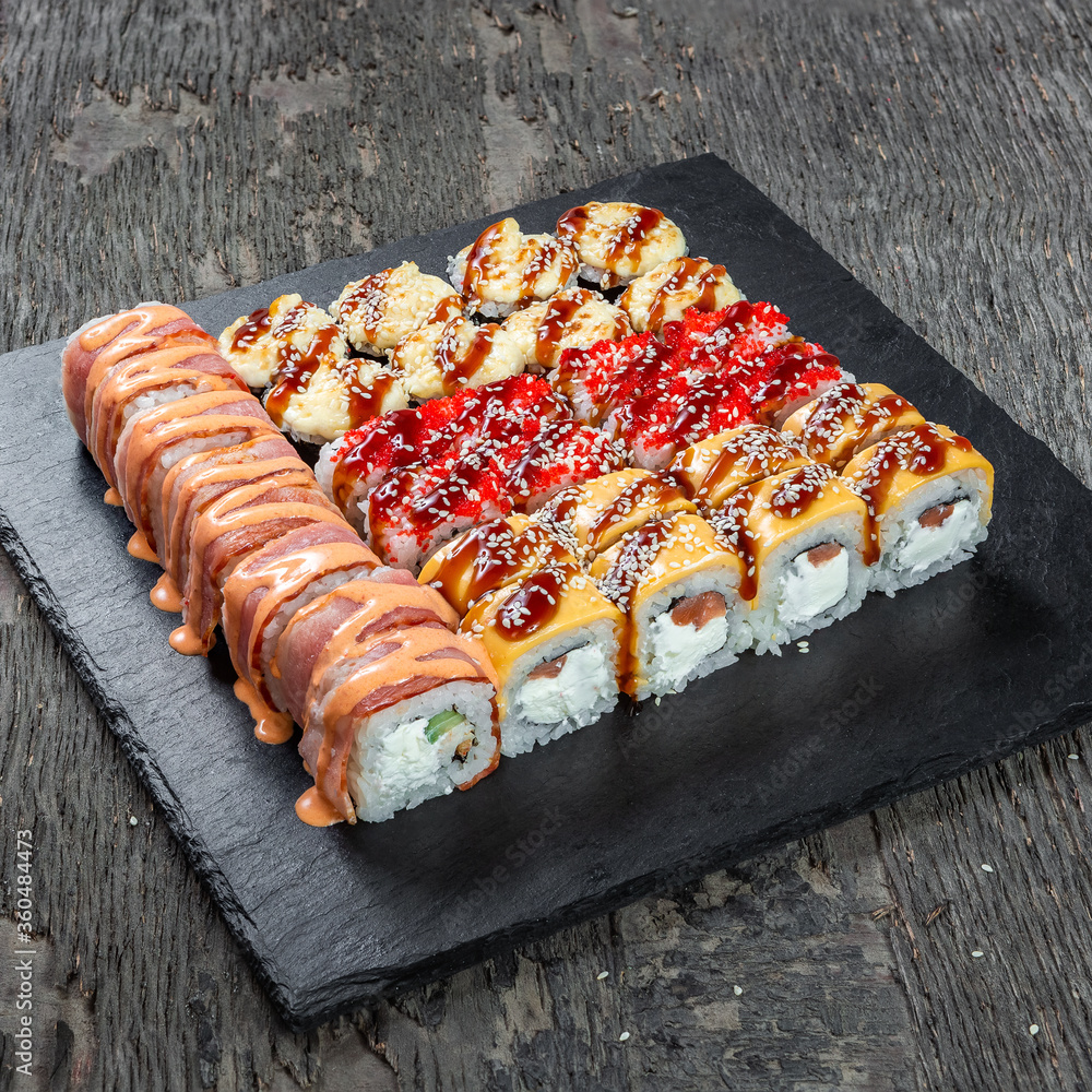 Japanese cuisine. Seafood, vegetables and meat. Sushi and rolls big set isolation on a wooden table background