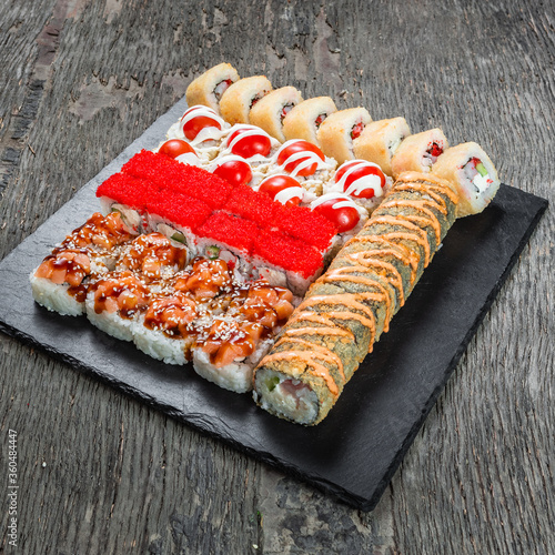 Japanese cuisine. Seafood, vegetables and meat. Sushi and rolls big set isolation on a wooden table background