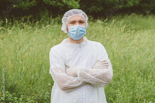 Man in protective suit, medical mask and rubber gloves for protect from bacteria and virus photo